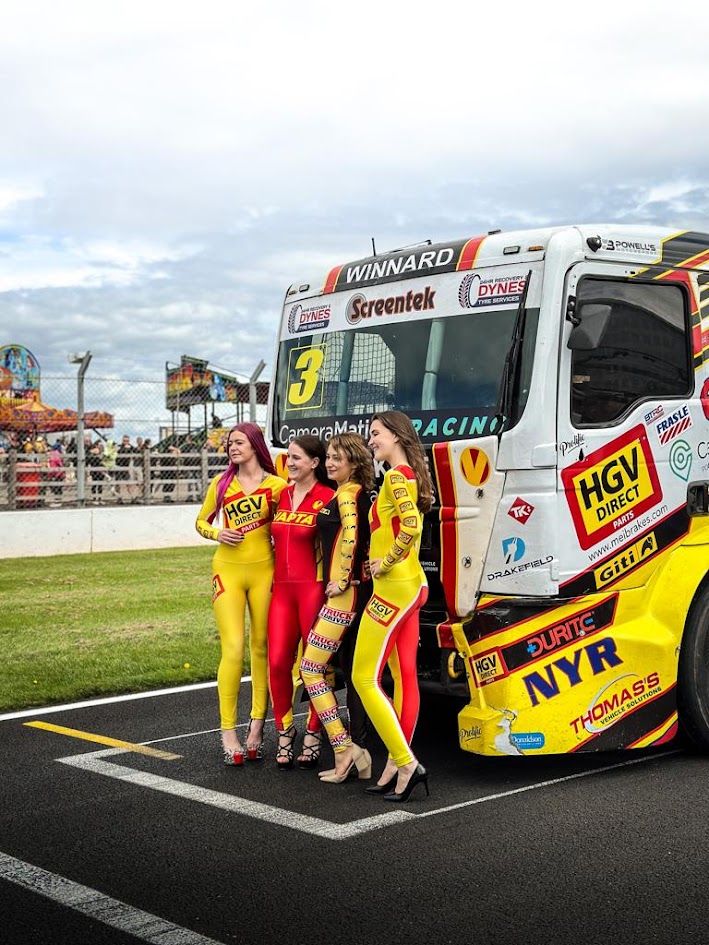 Grid team in VAPTA and HGV Direct race suits beside race truck number 3 on the starting grid