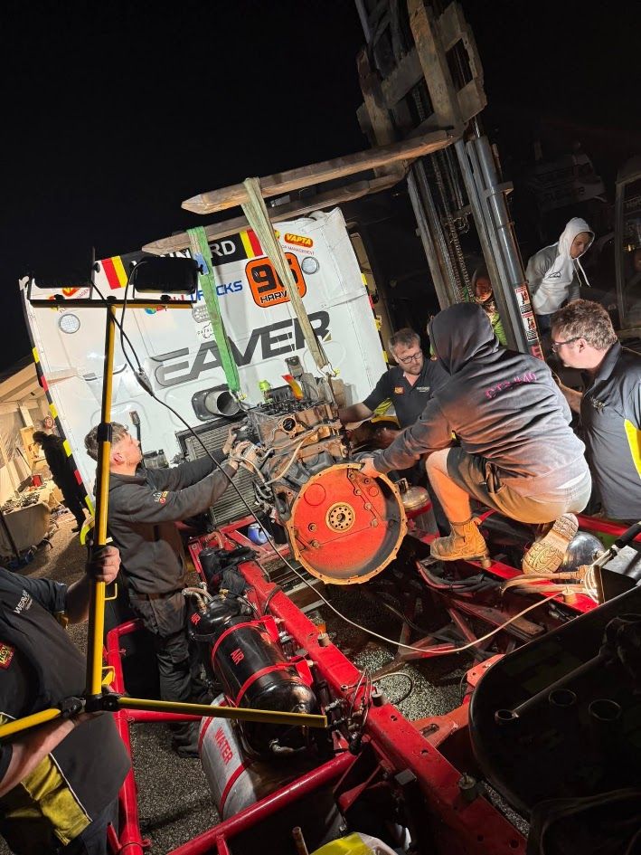 Team mechanics carrying out a trackside engine change on a VAPTA-branded race truck at night