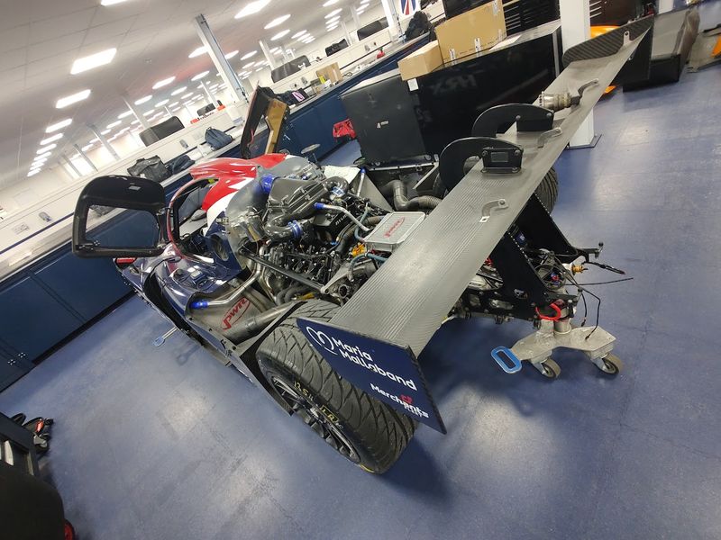 Prototype race car being serviced in a motorsport workshop
