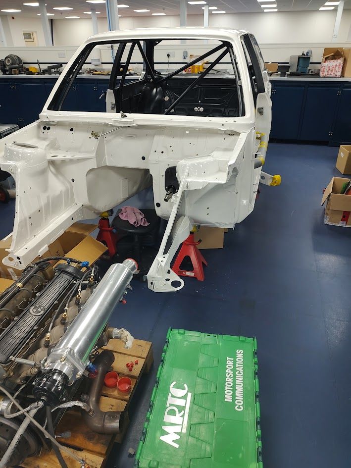 Race car shell with roll cage being built up in the workshop