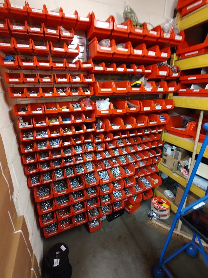 Wall of labelled small-parts bins in a workshop store