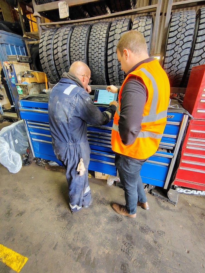 VAPTA trainer showing a workshop technician the system on a tablet at his toolbox