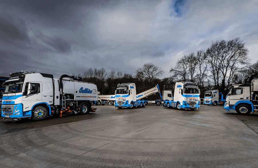 Collins Earthworks Volvo trucks, tipper and road sweeper lined up in the yard