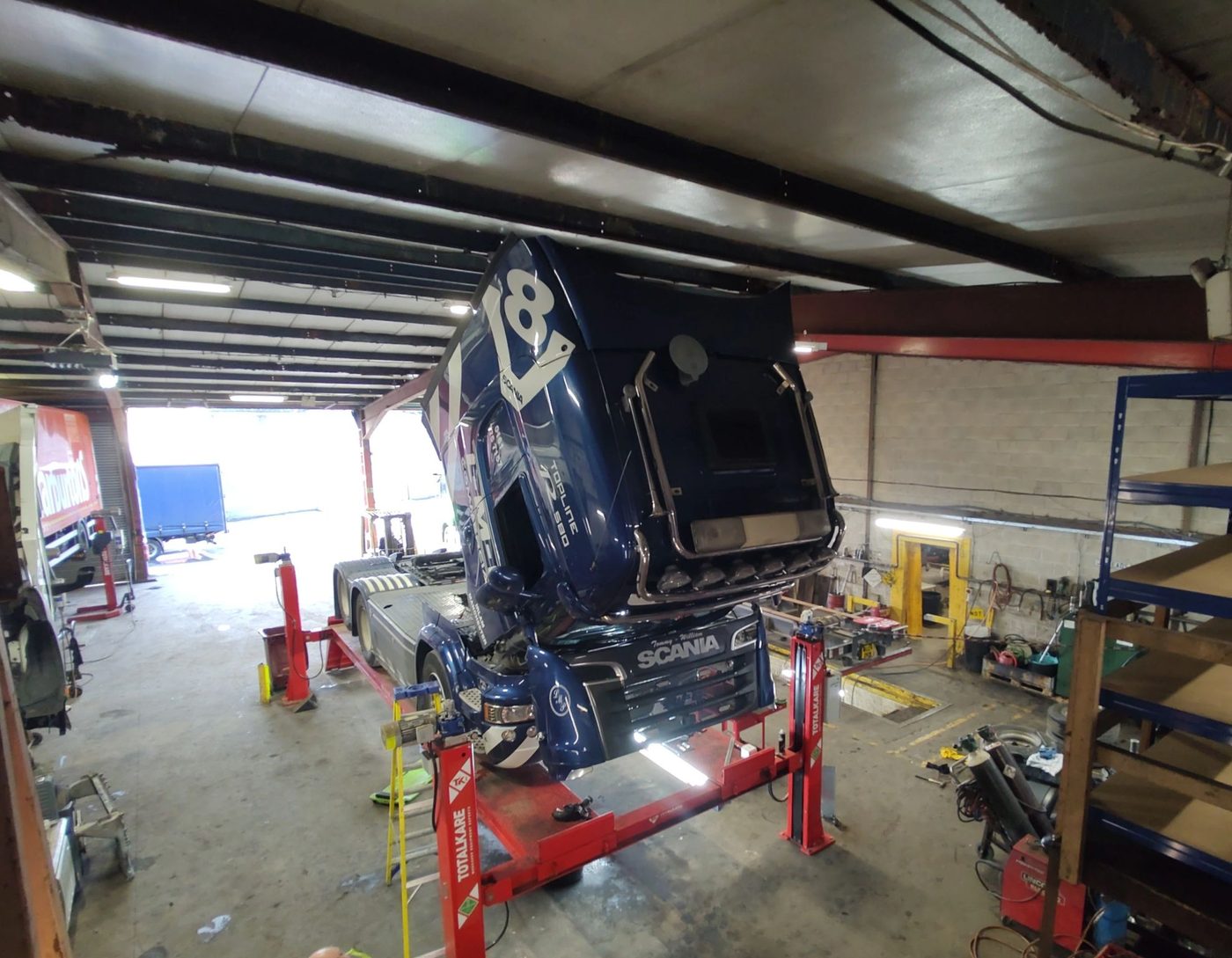 HGV on a four-post lift in a commercial vehicle workshop running VAPTA